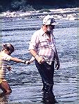 Jennifer Reynolds holds on to Inky Moore's shirt tail getting into position for smallmouth fishing on the Susquehanna near Three Mile Island.Mid 70s.